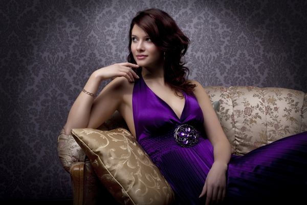 坐在沙发上的紫裙美女图片