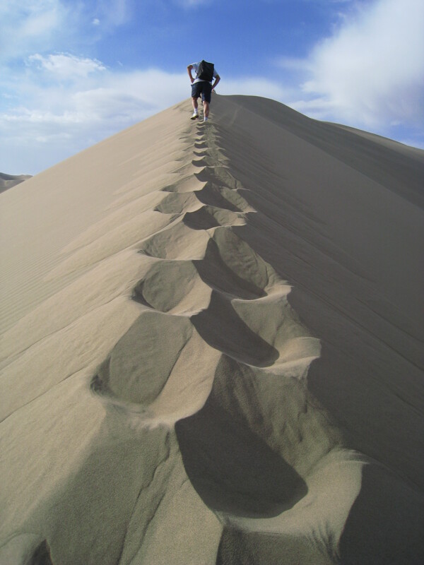 旅行者爬上沙丘图片