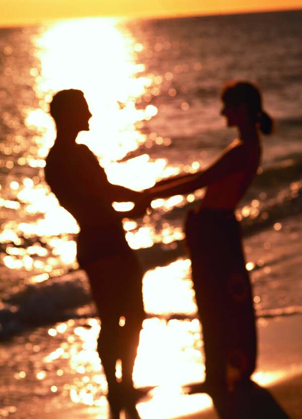 夕阳下的海滩情侣图片