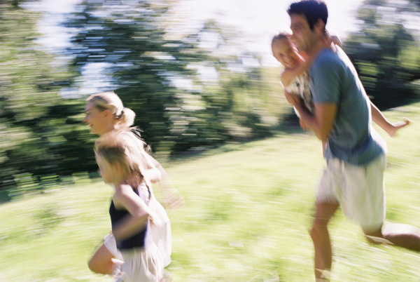 草地上奔跑的幸福家庭图片