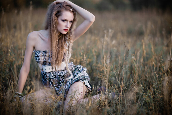 坐在草地上的野性美女图片