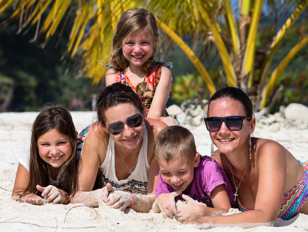 趴在沙滩上晒太阳的幸福家庭图片