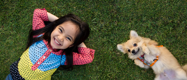 躺在草坪上的小女孩与小狗图片