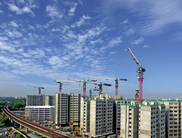 建筑工地上多臺(tái)起重機(jī)在藍(lán)天白云下作業(yè)