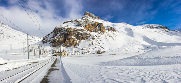 高山前的雪地道路图片