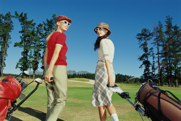 拖着高尔夫球杆的时尚美女图片