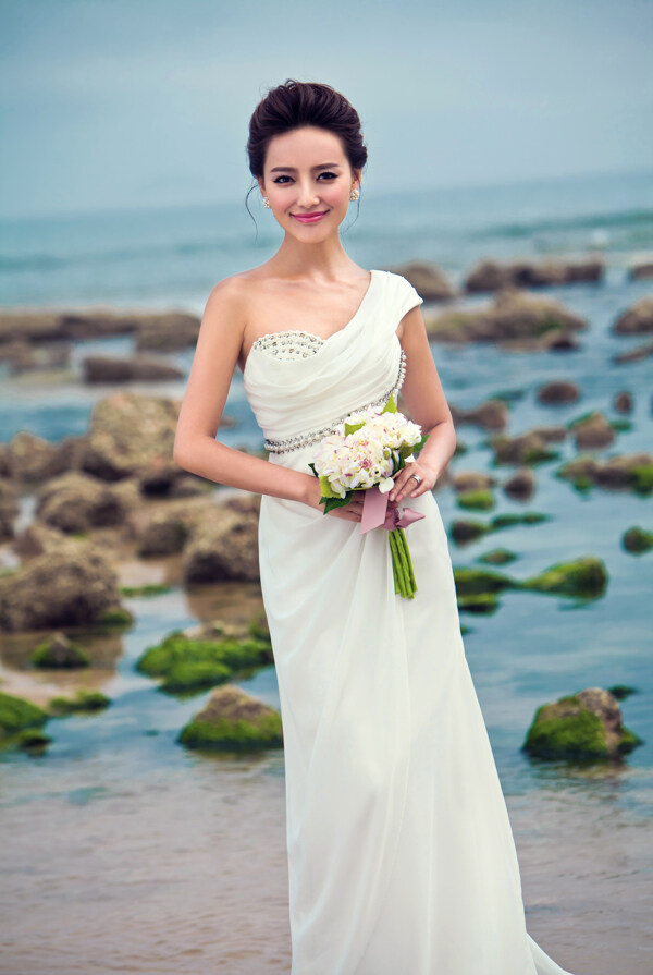 大海边手拿鲜花的新娘图片