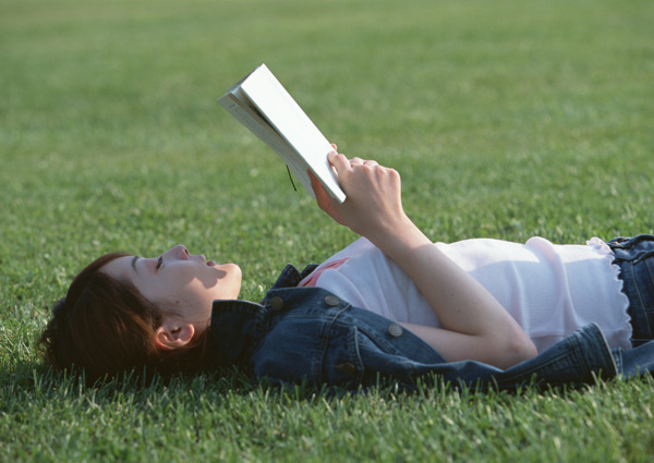 躺在草地上看书的女人图片