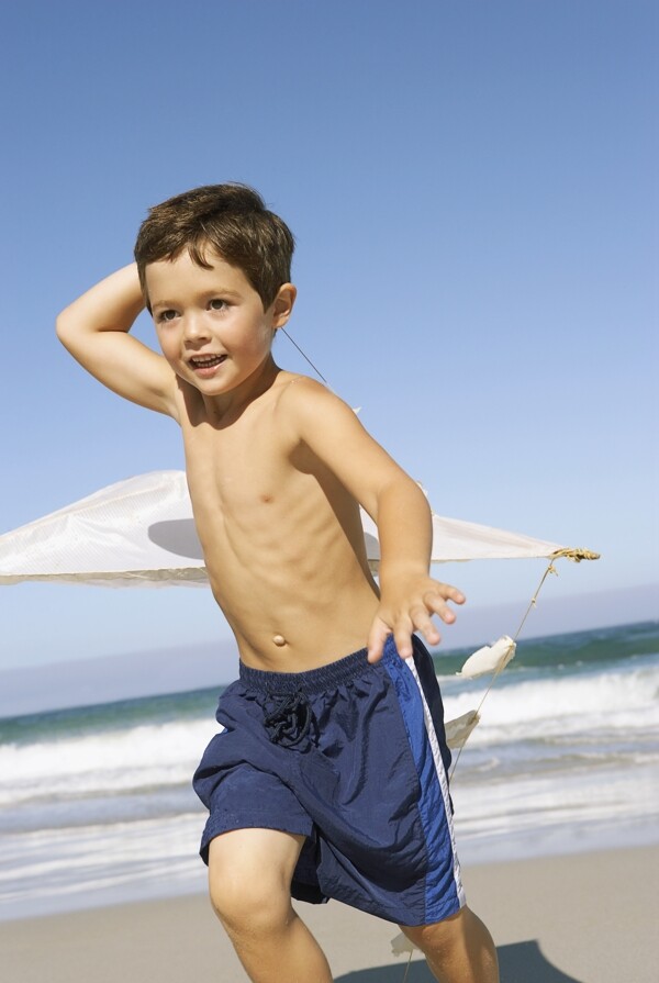 沙滩上放风筝的小男孩图片