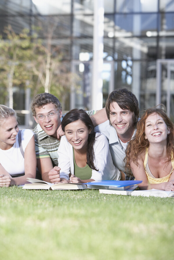 趴在草地上的开心大学生图片