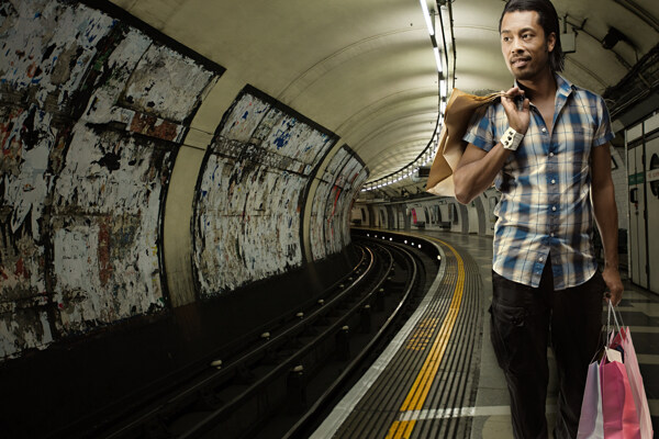 行走在地铁隧道的购物男人图片