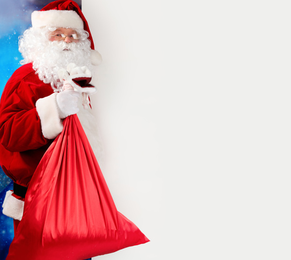 空白广告牌旁边手拿礼品袋的圣诞老人图片