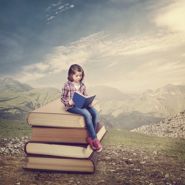 坐在书本上看书的小女孩图片