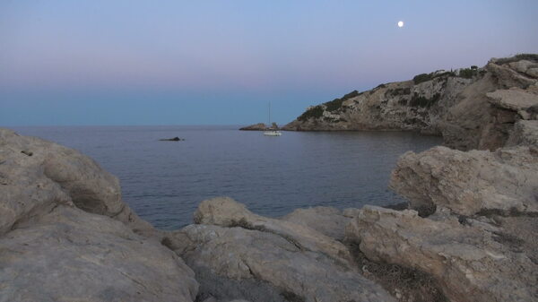 在夜晚的天空和孤独的小船在湾股票视频的月亮