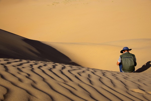 在沙漠里独坐沉思的人图片