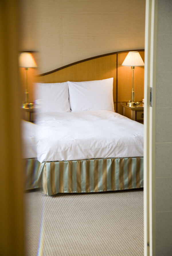 酒店客房内整洁的床和台灯图片