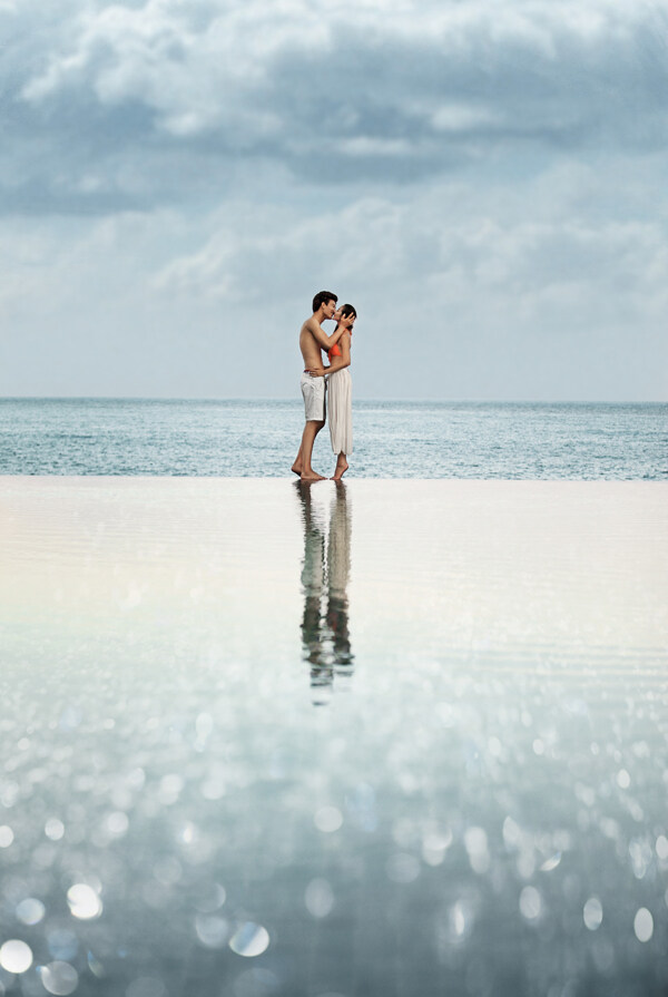 海滩上接吻的婚纱情侣图片